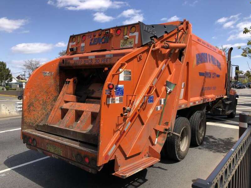 Orange garbage truck along Hudson County Route 501 (John F Kennedy Boulevard) at 32nd Street and the Bergen Turnpike in Union City, Hudson County, New Jersey