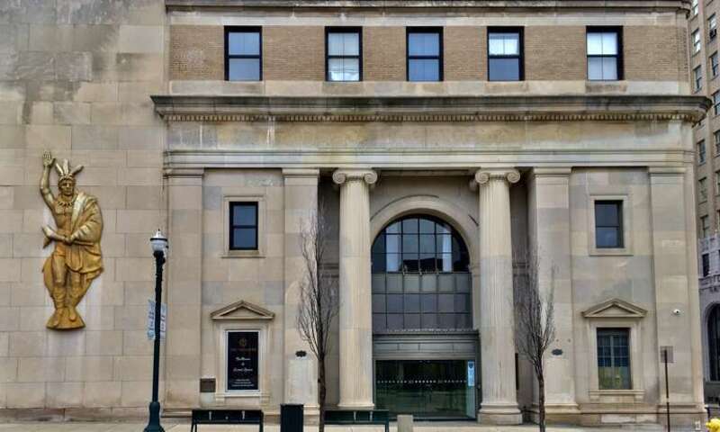 As seen in downtown Pontiac, Michigan, December 2020: a pair of proud Ionic columns flank a spacious arched portal at the grand entrance to the Neoclassical-styled 30 North building, located at the northeast corner of Saginaw and Lawrence Streets. At