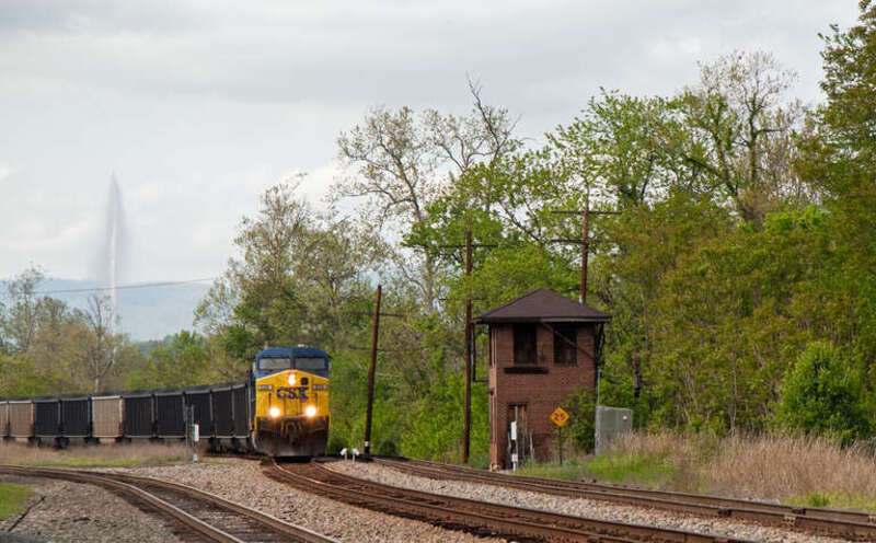 A CSX train of loaded coal hoppers makes it way through Lynchburg, VA.  The railroad shares this part of the city with the Riverfront Festival Park, historic sites, walking trails, restaurants and lots of pedestrians.  The Langley Fountain, which is