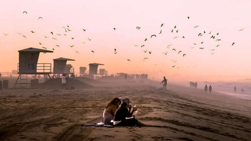 Two ladies watching the early morning surfers with some coffee.

Surf City, USA  a.k.a. Huntington Beach, California