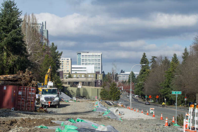 Looking north along 112th Ave SE at SE 6th St.  The box in the center is the future south portal of the Downtown Bellevue tunnel.  The highrises of Downtown Bellevue are visible in the distance.
