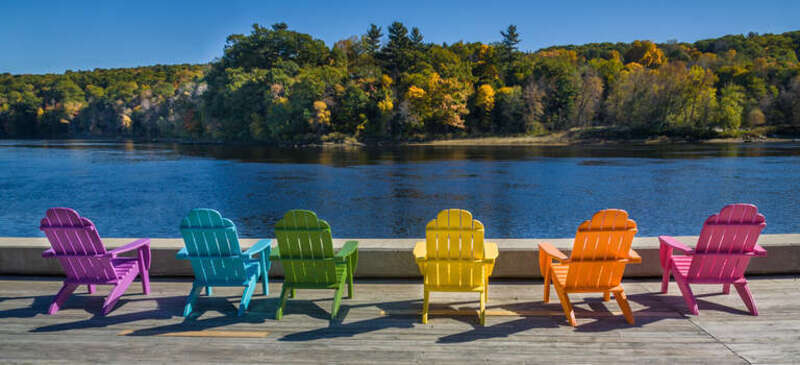 This photo is of the Kennebec River in Hallowell, Maine.  I thought the multicolored Adirondack chairs were rather festive looking in the bright sun.  If the pink one was red, the order of color would follow that of a rainbow.