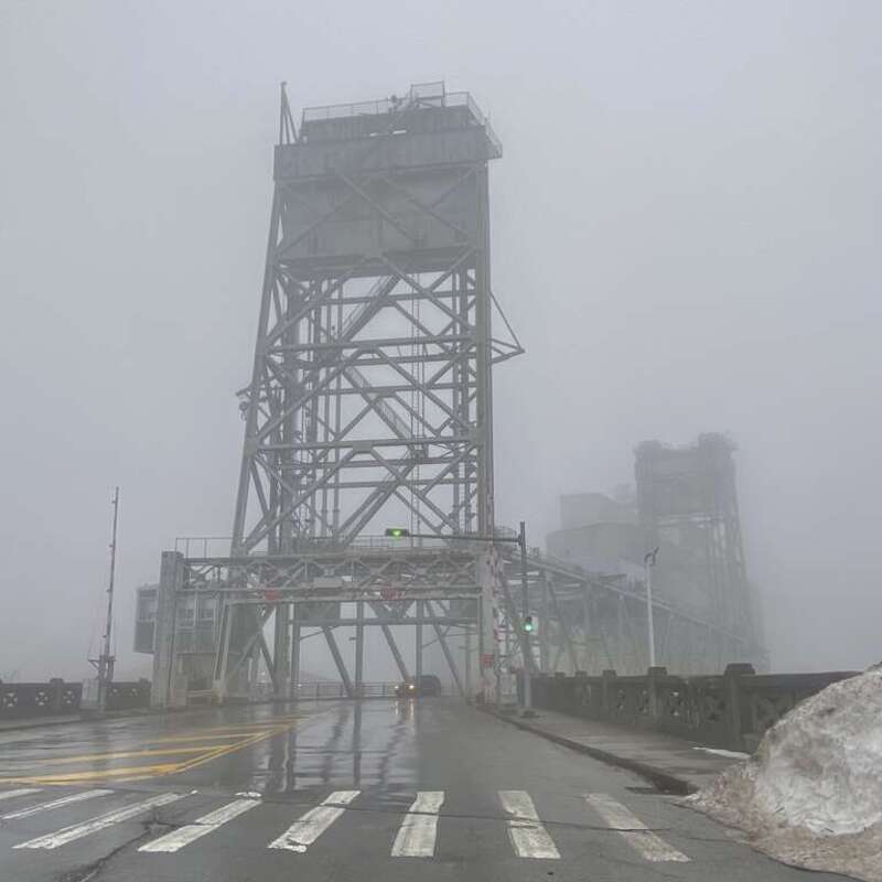 On a mild December 2022 afternoon in which a temperature of 50°F belied the occurrence of an historic blizzard less than a week prior, the Michigan Avenue Bridge rises proudlty amidst a thick fog over Buffalo, New York.