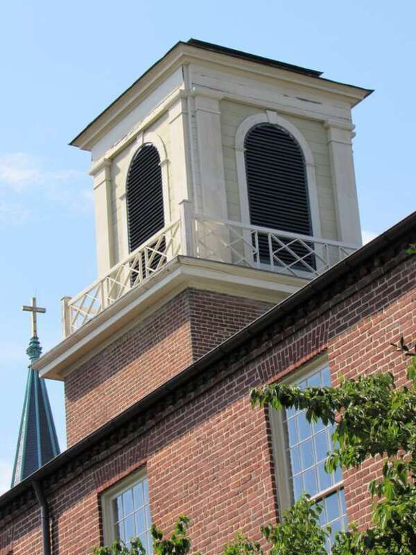 The bell tower of the Old Presbyterian Meeting House in Alexandria, Virginia. The spire of the Basilica of St. Mary is in the background.
