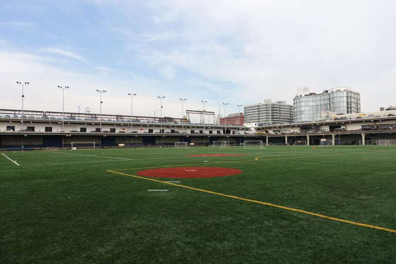 Looking out from the adult baseball infield at the west end of the courtyard field of Pier 40, at the west end of Houston Street at West Street in Hudson Square, Lower Manhattan. Following the 2020 renovations to the turf field, it features new and