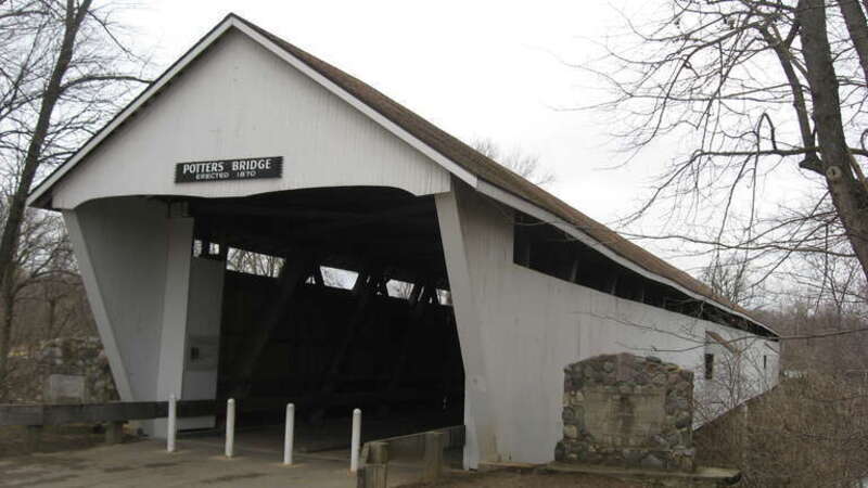 Southern portal and eastern (upstream) side of Potter's Covered Bridge, which spans the White River north of Noblesville in Noblesville Township, Hamilton County, Indiana, United States.  Built in 1871, it is listed on the National Register of