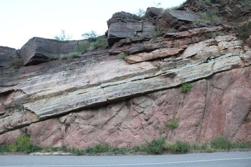 A view of the Precambrian-Cambrian nonconformity along Manitou Avenue (U.S. Route 24 Business) in Manitou Springs, Colorado. The pink-colored rocks just above the road level are Pikes Peak granite. The light-colored sandstone above the granite is