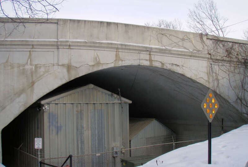 w:Queen Avenue Bridge in Minneapolis, Minnesota.  The bridge formerly crossed the w:Twin City Rapid Transit line, but the line is no longer in use.  The sheds underneath the bridge house streetcars of the Minnesota Streetcar Museum.  Land past the