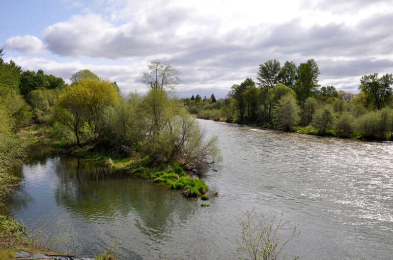 The Rogue River flows through TouVelle State Recreation Site, north of Medford in the U.S. state of Oregon. View is upstream (east) from the bridge carrying Table Rock Road.