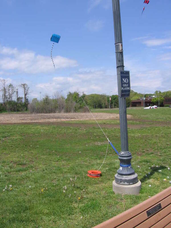 Three parafoils at Savin Rock in West Haven, Connecticut.  The tethered blue one is large enough to require a heavy line and a climbing carbiner.  The red one aloft at upper right is only slightly smaller than the blue one.  Still on the ground and