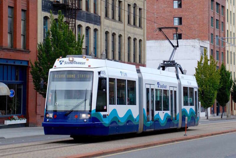 Sound Transit Tacoma Link car 1003, a 2002 Škoda 10T, southbound in the center of Pacific Avenue, in a slightly raised trackway that is reserved for use only by Tacoma Link light rail cars.