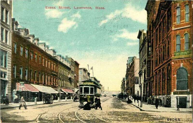 Divided back postcard of a streetcar on Essex Street in Lawrence, Massachusetts, postmarked 1911. The building at right is 296 Essex Street, with a sign for C.E. and H.J. Bradley Real Estate.