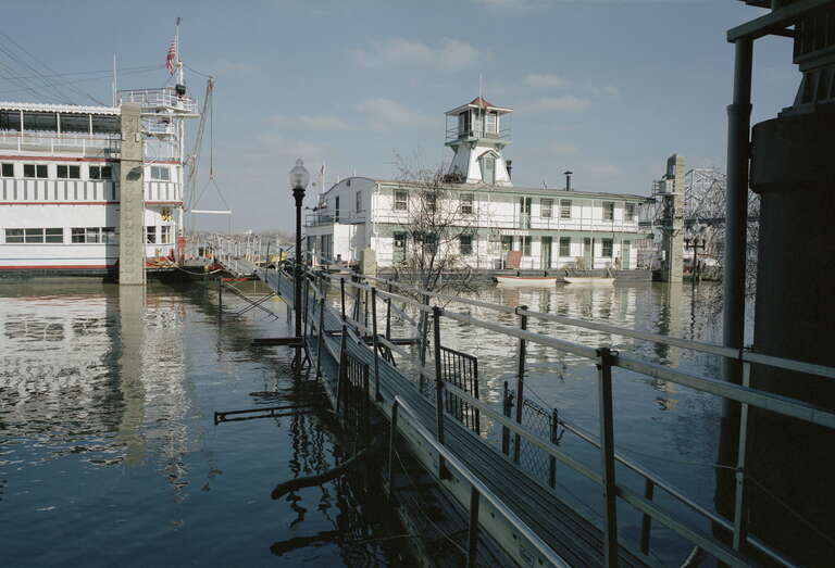 Looking N from River Road between 3rd and 4th Sts.:
Temporary scaffolding used to cross high water to &quot;Belle of Louisville&quot; (left) and wharf boat &quot;Mayor Andrew Broaddus&quot; (recently remodeled).
Ohio River mile 604
Upper gauge = 26 feet (12 feet is