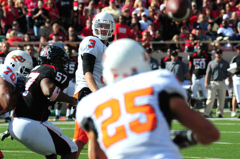Brandon Weeden passes the football to Josh Cooper. Oklahoma State Cowboys vs. Texas Tech Red Raiders. Lubbock, Texas. October 16, 2010.