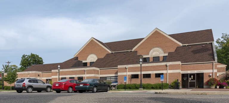 A view looking northwest at the Grove City Municipal Safety Complex. The location holding the Grove City mayors court and police department headquarters. Power lines have been removed from the top-right as well as the license plate of unknown