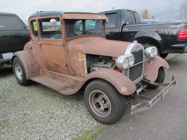 One among many interesting vehicles seen in the parking lot at the Early Bird Swap Meet in Puyallup, Washington.  The quad headlights don't go with the stock &quot;A&quot; body very well.  It looks like those rear fenders have been widened.