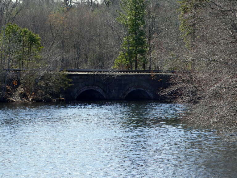 A double-arch bridge that carries the Worcester Line over the Sudbury River in Ashland, seen in March 2022. The stone bridge was built in 1834 for the Boston and Worcester Railroad - one of three such original bridges remaining in the town. It was