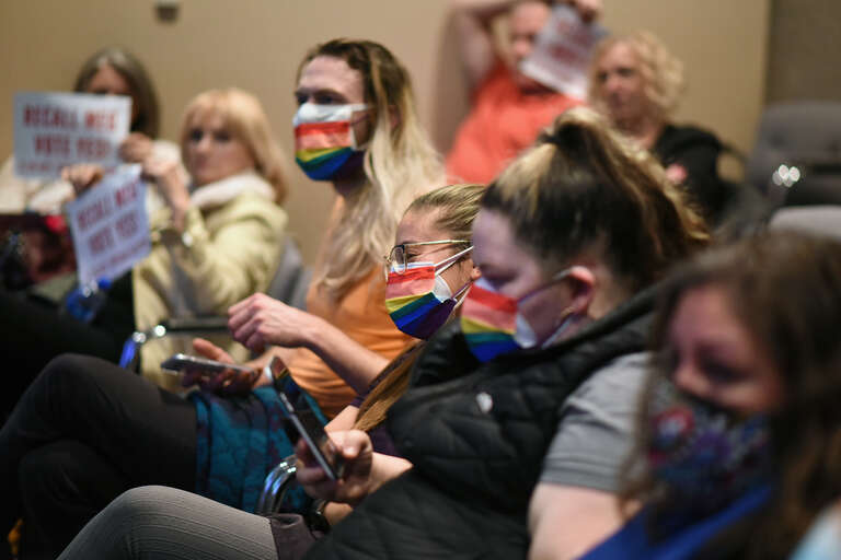 Individuals wearing pride masks in support of Christopher Constant. Constant, who is openly gay, was insulted with a homophobic slur in the previous meeting, prompting an outburst of cheering, applause, and flag-waving by the audience.

This photo is