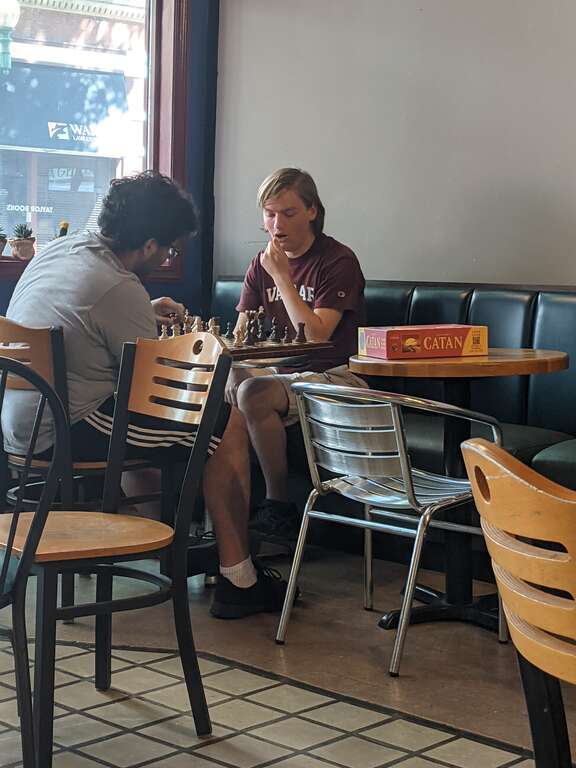 Two young men play chess at Taylor Books, 226 Capitol Street in downtown Charleston, West Virginia on the Fourth of July.