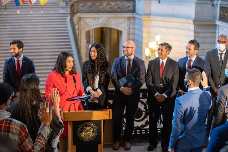 San Francisco Mayor London Breed swears in members of the San Francisco Human Rights Commission's LGBTQI+ Advisory Committee at SF City Hall, as members of the commission and City officials look on.