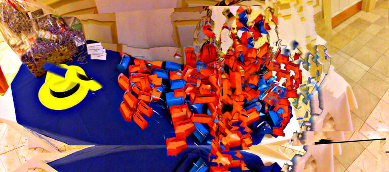 On the way out, a table of boxed chocolates in a jumble, colorful hats, a wrapped gift basket; all entangled like so many quarks amongst the gluons, brought to you in PANO-vision with the wave of a multimodal electronic device.