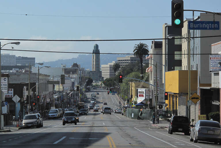 View on Seventh Street in the Westlake area of Los Angeles, looking west toward the Bullocks Wilshire building. The Hollywood Hills are in the background.
