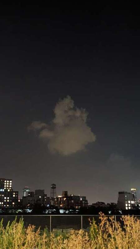 A cloud of smoke in the night sky that left after the firing of a small firework