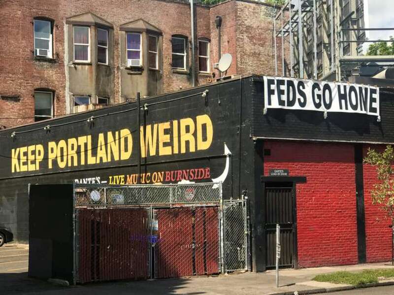 A, &quot;FEDS GO HOME&quot; sign in downtown Portland in August 2020, hung up on the same building as the iconic, &quot;Keep Portland weird&quot; sign.