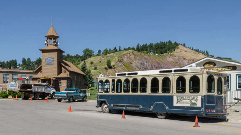 A view of the visitor center of the Homestake mine in Lead, South Dakota. A bus is visible in front of the building. At the left, &quot;JL's Gift Shop&quot; is visible.