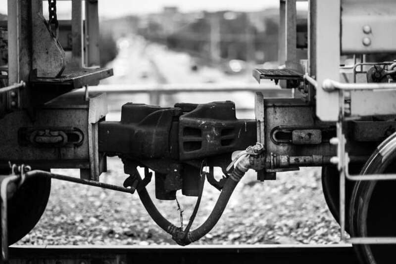 500px provided description: Train cars sit hitched over the Lamar Bridge in Austin, Texas. [#street ,#train ,#trolley ,#bokeh ,#black and white ,#monochrome ,#railroad ,#rail ,#coupling ,#moped]