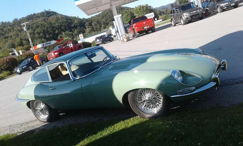 Jaguar E-Type coupe parked at ExxonMobil gas station on VT Rte 15 in Morrisville, Vermont.
