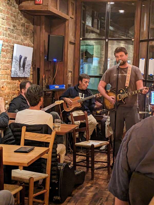 Open mic at The Local on 824 Hinton Avenue in the Belmont neighborhood of Charlottesville, Virginia. Michael Clem and Brennan Gilmore play guitar behind performer.