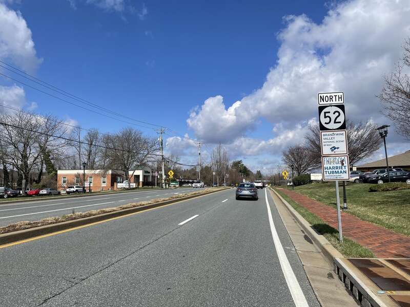 Northbound Delaware Route 52 (Kennett Pike) past the intersection with Buck Road in Greenville, Delaware
