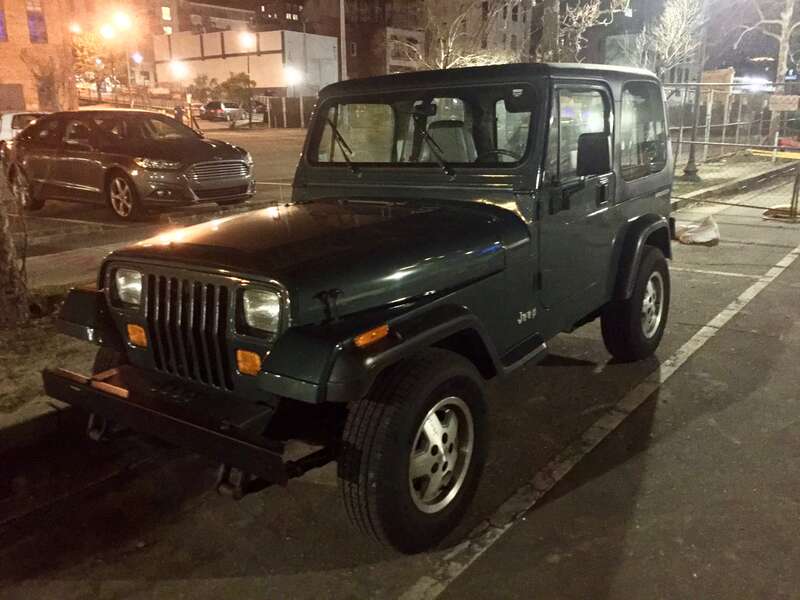 Front left side view of Jeep Wrangler (YJ) base model finished in green. Factory condition and equipment. Photographed at night in Willmington, North Carolina.