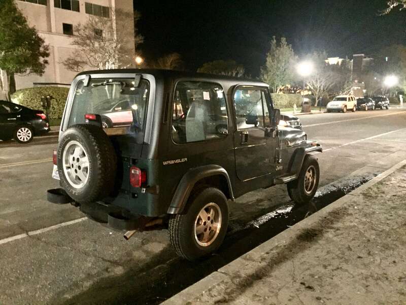 Rear right side view of Jeep Wrangler (YJ) base model finished in green. Factory condition and equipment. Photographed at night in Willmington, North Carolina.
