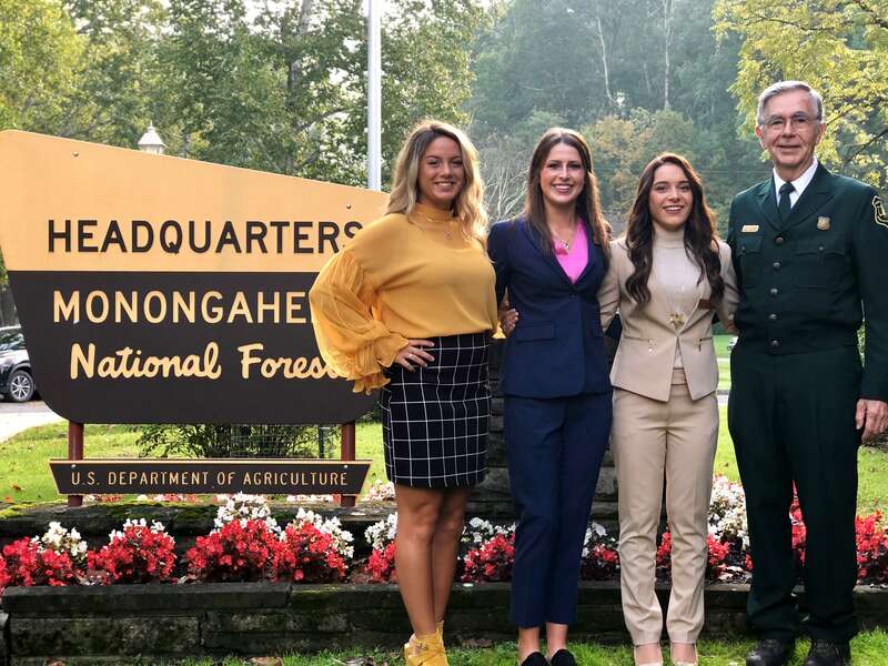Forest Supervisor Clyde Thompson, Maid Silvia Alia Figueroa and Maids of Honor Hannah Shiflett and Grace Lindsey in front of the Supervisors office in Elkins, Monongahela National Forest, October 4, 2018. (USDA Forest Service photo by Kelly Bridges).