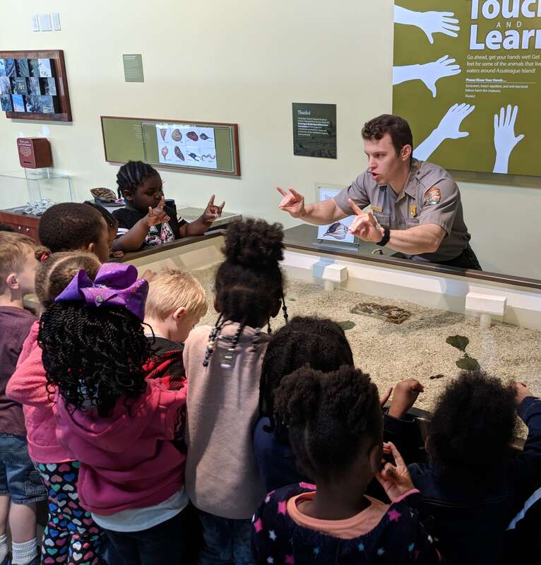 A man in a uniform gestures with children, who make the same signs back to him.
Assateague Island National Seashore: Connecting with the next generation will help protect our oceans and beaches.
Keywords: 2019 Region 1