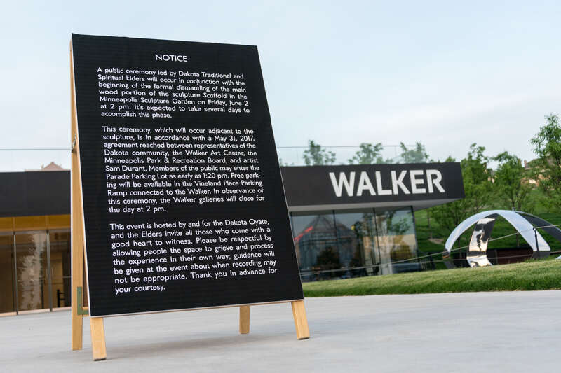 A sign that displays information about the Dakota Ceremony at the Walker Art Center.
Photograph by Lorie Shaull.
&quot;Scaffold,&quot; a wood &amp;amp; steel sculpture by the artist Sam Durant, was a composite of the representations of 7 historical gallows used in