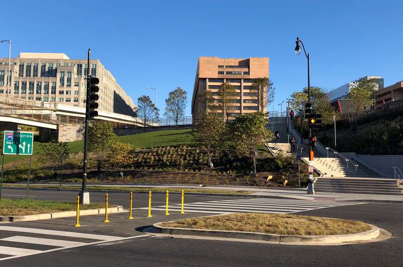Small, freshly planted plants and trees on the far side of a crosswalk on Maine Ave. SW, Washington, DC.
New plantings help beautify Banneker Park