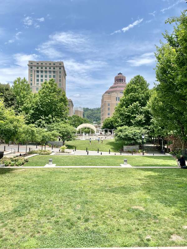 On the left, built in 1924-1928, this Classical Revival-style building was designed by Frank Pierce Milburn to serve as the Buncombe County Courthouse, replacing a previous courthouse that stood immediately in front of the present building, which was