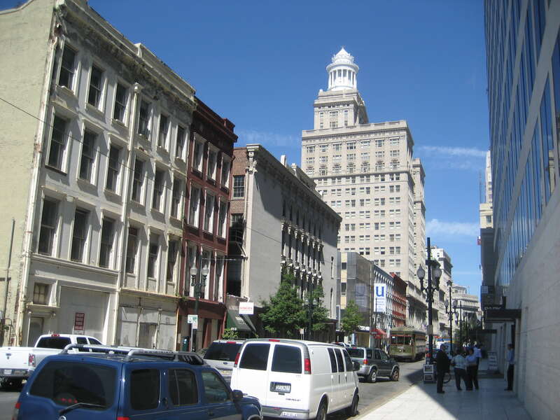 New Orleans Central Business District. View down Carondelet Street from Poydras Avenue, with the dome of the Hibernia Building visible; a St. Charles Streetcar seen.