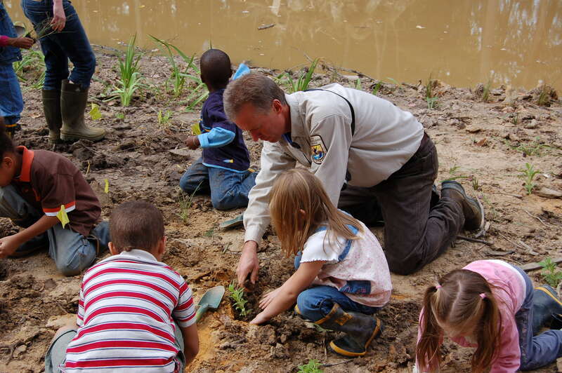 Biologist Rich Mason helps students plant a schoolyard wetland. 
Credit: Laurie Hewitt/USFWS