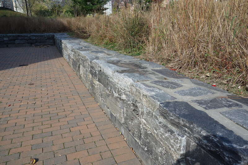 A stone wall in front of the Strecker Memorial Laboratory at the east side of Southpoint Park, at East Road south of South Loop Road at approximately Manhattan 53rd Street in the southern half of Roosevelt Island, Manhattan. Can also be used for