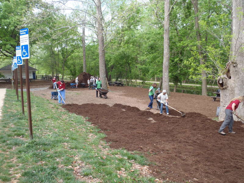 Volunteers spread mulch throughout the day use area and concession stand.