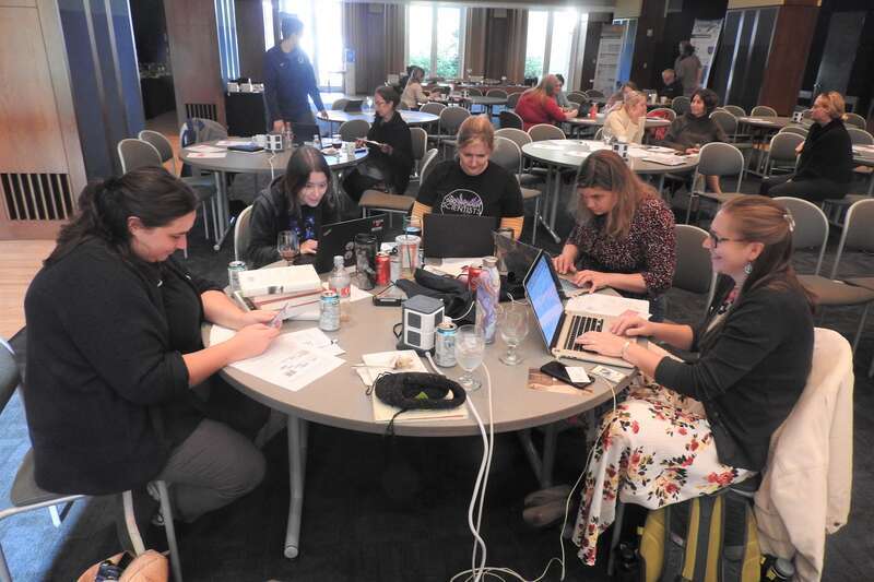 Looking north at industrious editors at a round table and elsewhere