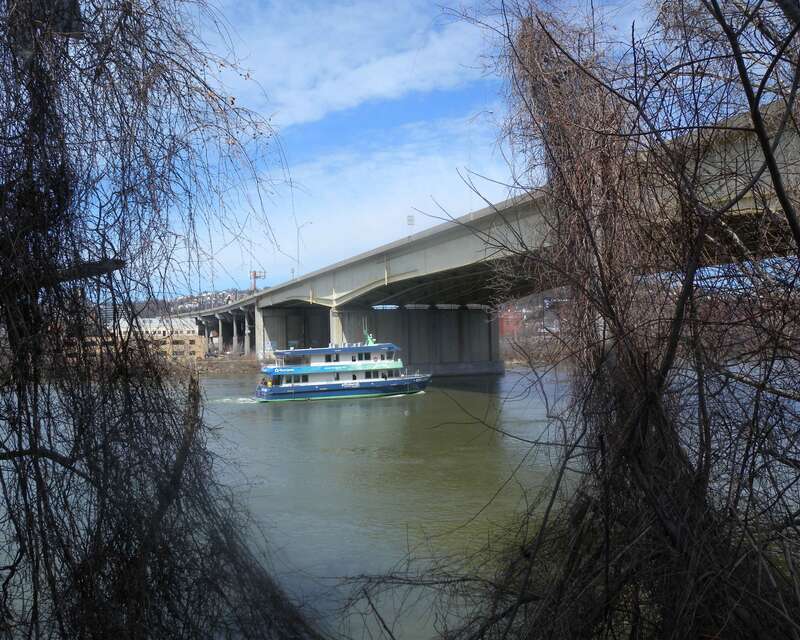 Looking north from left bank at Veterans Bridge on a mostly sunny midday.