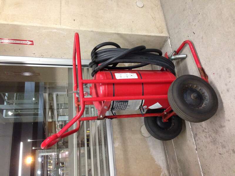 Wheeled Fire extinguisher and a sign inside a parking lot