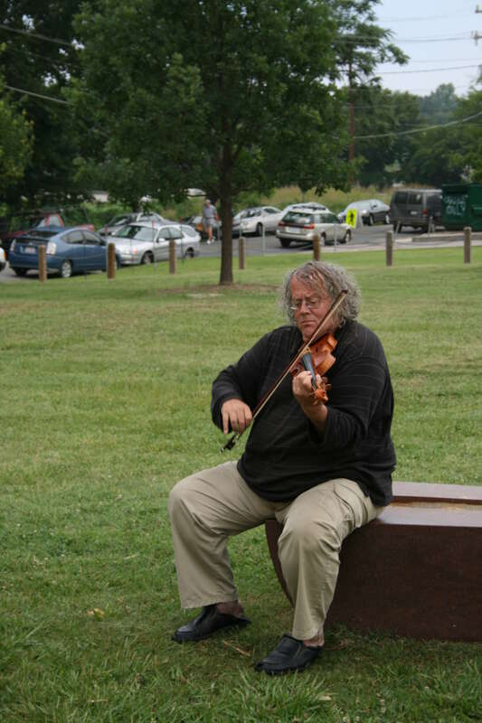 A violinist playing at the Durham Farmers' Market in the morning in Durham, North Carolina.