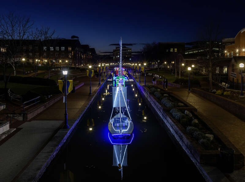 Illuminated holiday boat display in Carroll Creek, Frederick, Maryland, USA