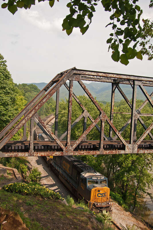 An train of empty coal hoppers heads west on the CSX 'James River Line' in Natural Bridge, VA.  The bridge above is the NS 'H' line.
